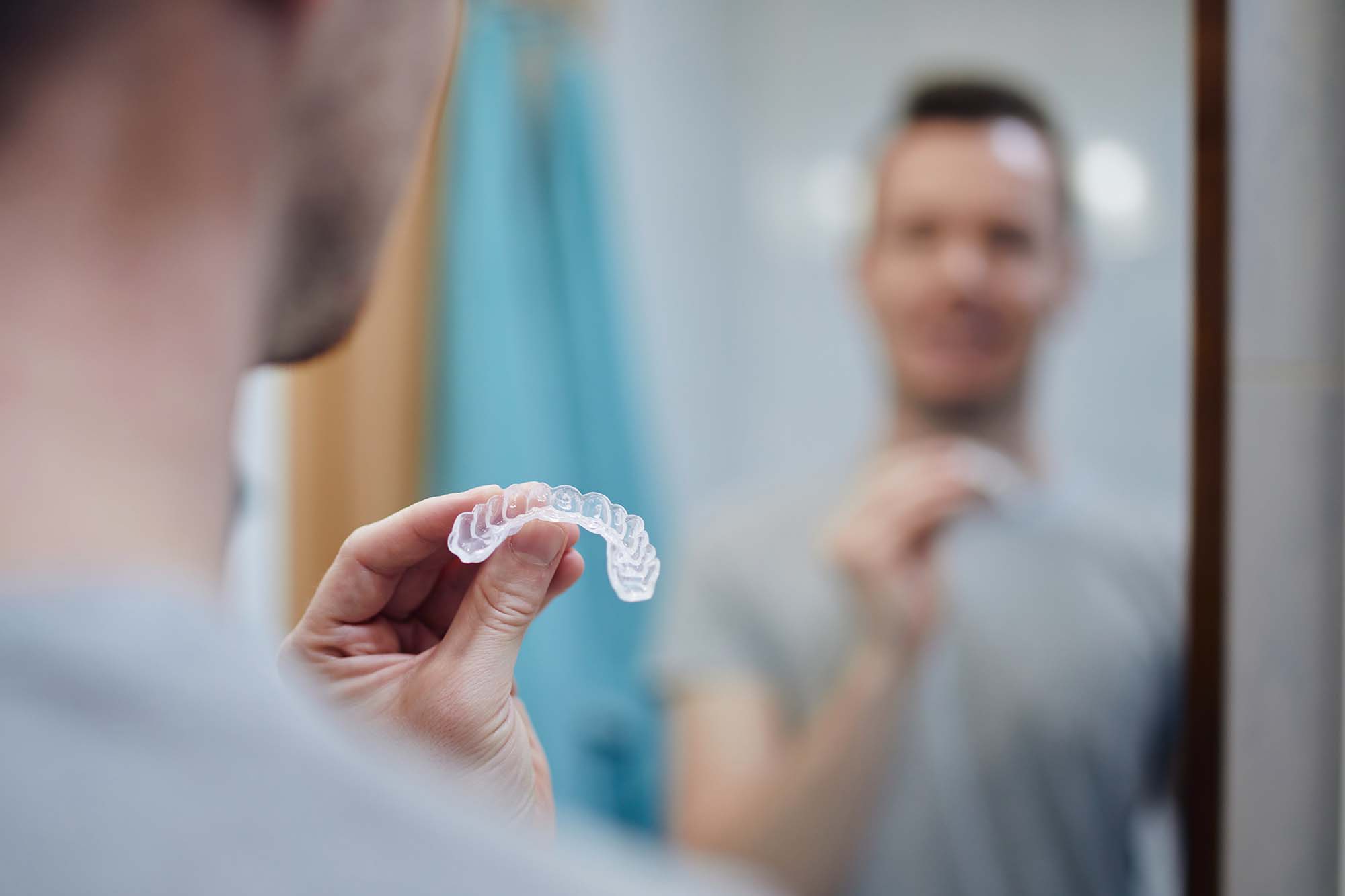 Man considering professional teeth whitening vs. DIY kit