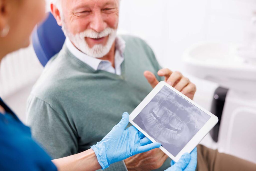 Dentist reviewing jaw X-ray with patient