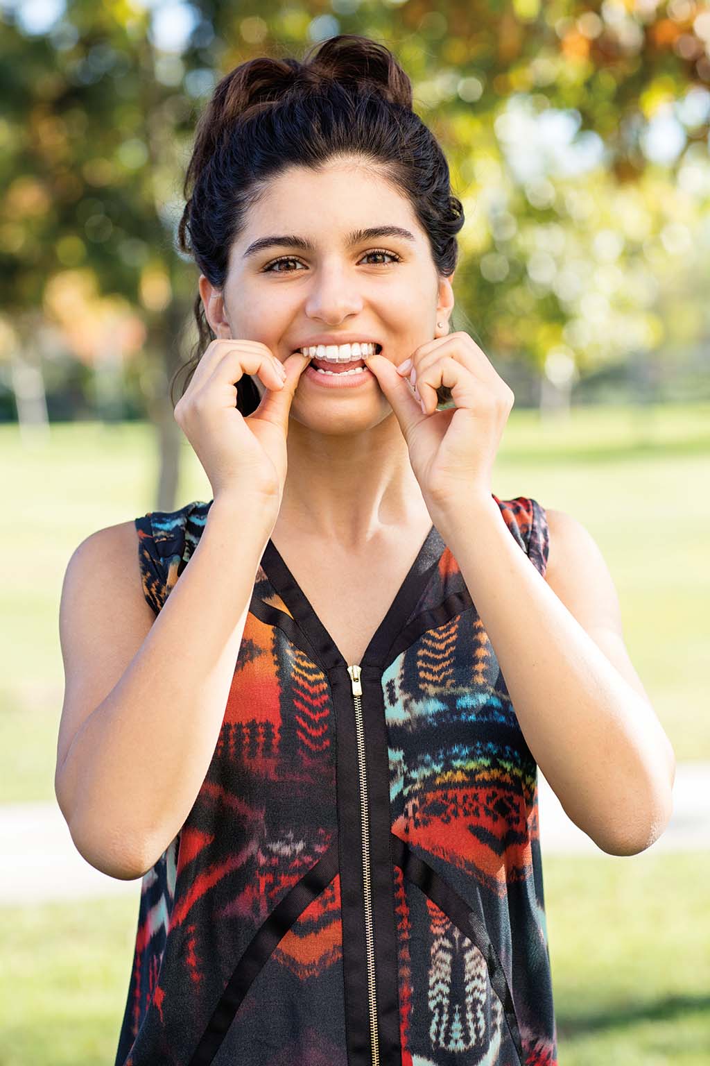 Teen using Invisalign clear aligner to straighten teeth