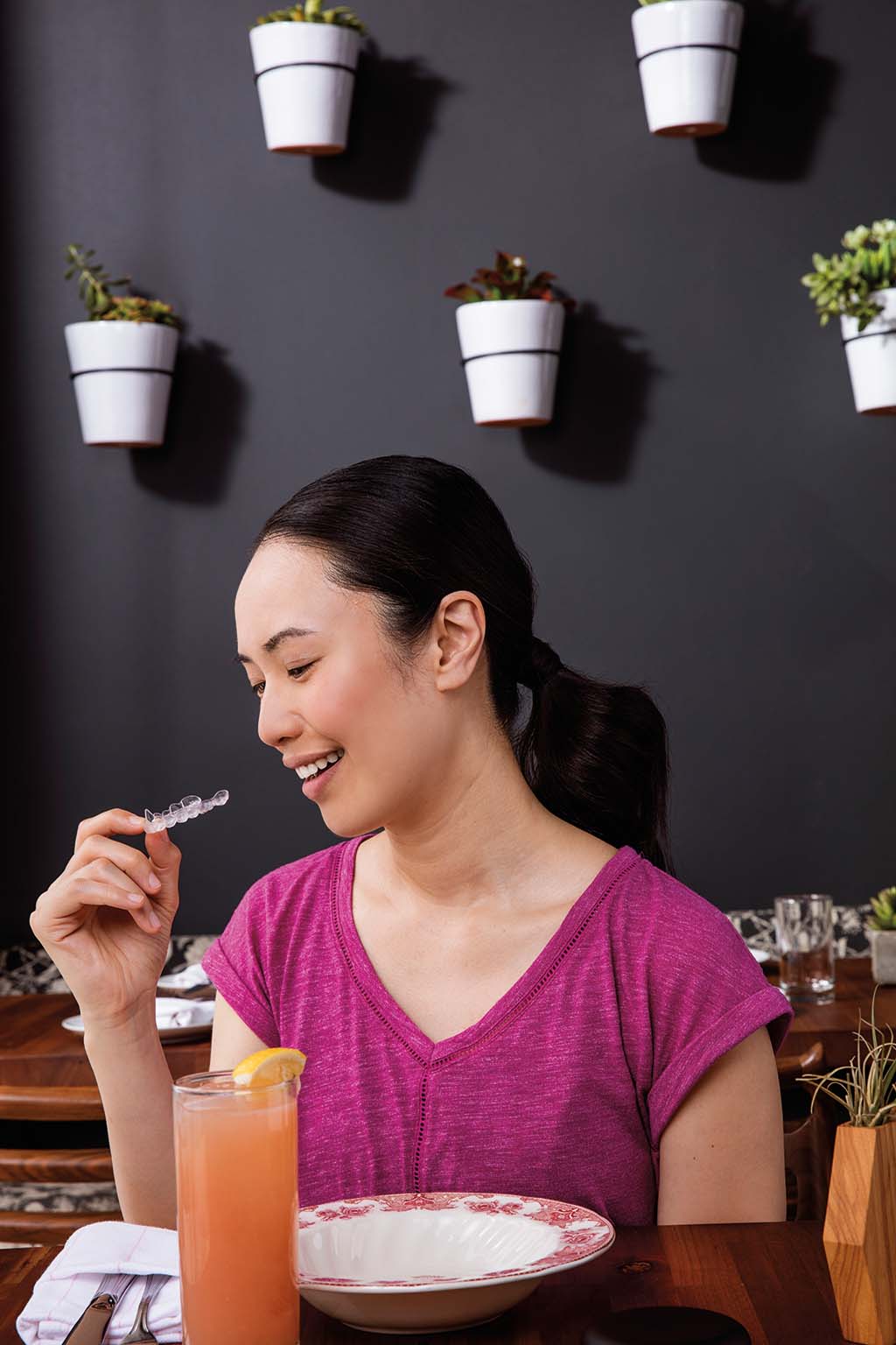 Woman removing Invisalign aligner for discreet eating